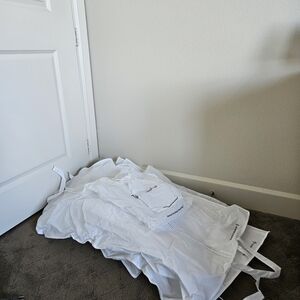 8 Garmet Bags Of Varying Sizes With Branding From THE REAL REAL